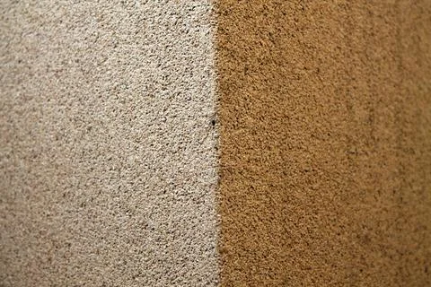 A closeup view of two-sided wall with white and brown bumpy grunge texture ba Stock Photos