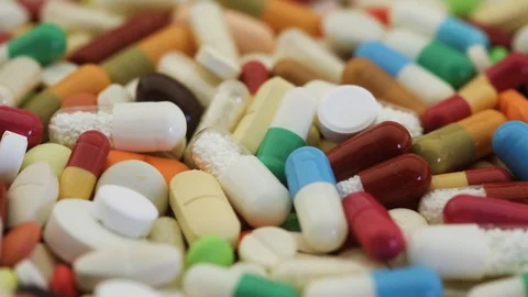 Closeup view of various medication pills spinning Stock Footage 95476852