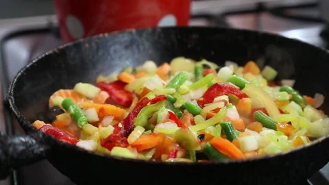 Closeup view of vegetables are fried in a pan. Shallow focus. Stock Footage 136047623