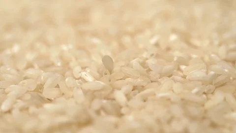 Closeup view video of white uncooked rice falling down on table Stock Footage 125621915