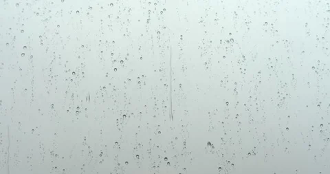 Closeup view water drops falling on glass. Rain storm running down on window Video stock 131660652