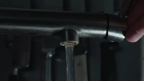 A CloseUp View of Water Flowing from a Stylish Stainless Steel Faucet Stock Footage 303829282