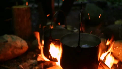 Closeup view of water kettles hanging over bonfire in outdoor summer camping Stock Footage 140321663