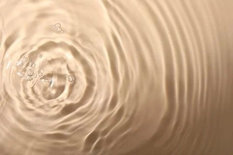 Closeup view of water with rippled surface on beige background Foto stock