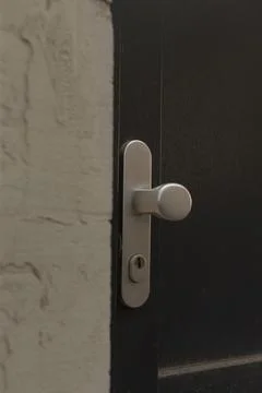 Closeup view of weathered silver door knob and textured wall surface Fotos Stock