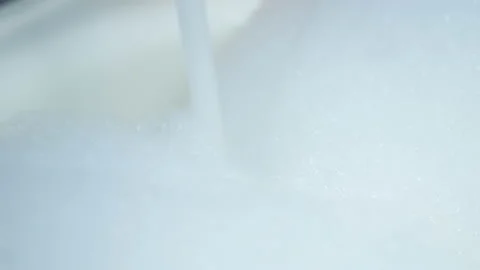 Closeup view of white bubbled foam in bathroom and running water. Stock Footage 154028669