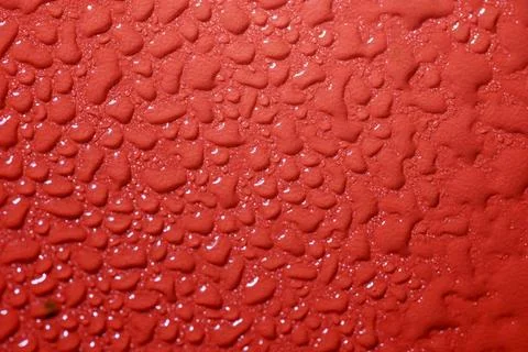 Closeup view of white fluid drops on a textured red background Stock Photos
