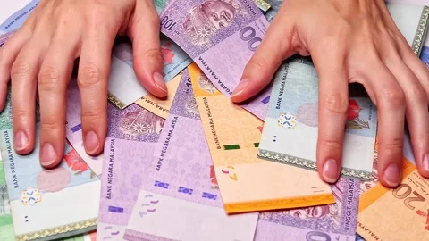 Closeup view of womans hands and brand new Malaysian ringgit (MYR) banknotes Stock Footage 300105416