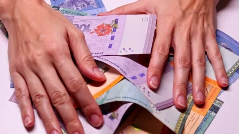 Closeup view of womans hands and brand new Malaysian ringgit (MYR) banknotes Stock Footage 300105838