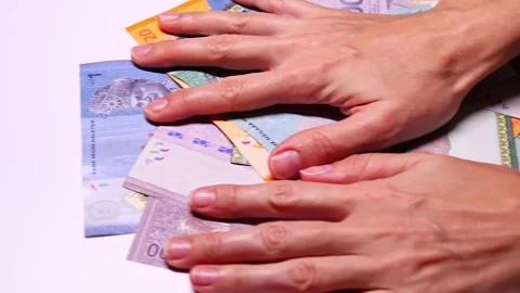 Closeup view of womans hands and brand new Malaysian ringgit (MYR) banknotes Stock-Footage 300106396