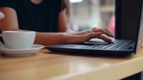 Closeup view of woman's hands typing on the laptop's keyboard in the coffee shop Stock Footage 79392368
