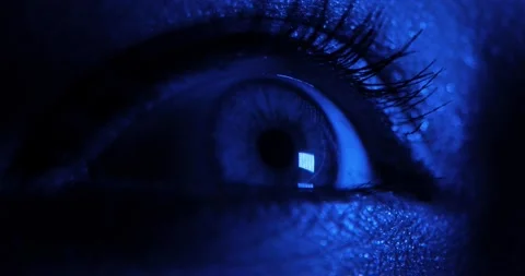 Closeup view of woman's opening beautiful eye in dark blue and red lights. Stock Footage 147347925