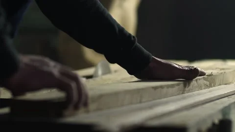 Closeup view of a woodcutter's hands while they are carefully pushing lumber  Stock Footage 134702065