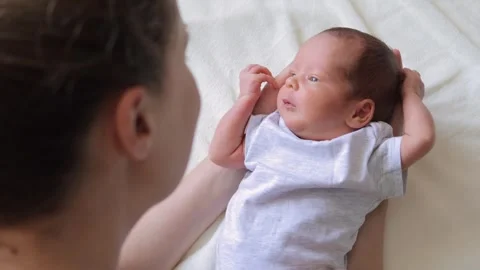 Closeup view of young unrecognizable affectionate mother gently playing her Vidéo 291550242