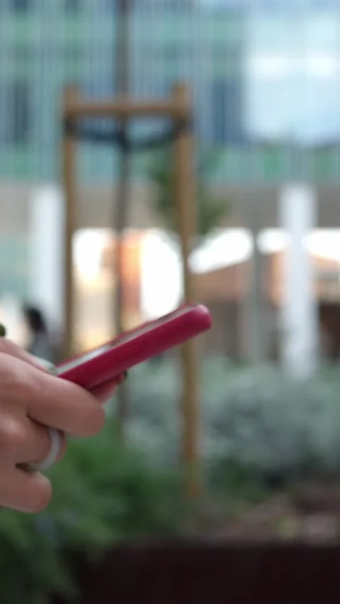 Closeup view of young woman using mobile phone in city while walking around Stock Footage 239171131