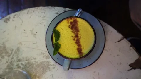 Closeup viewed from above of a cup of golden milk coffee with turmeric, pepper Stockbeeldmateriaal 166596153