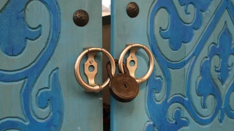 Closeup of a vintage padlock securing the handles of an old Stock Footage 344655229