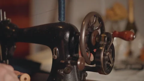 Closeup vintage sewing machine wheel rotating, metal gear and wooden handle Stock Footage 346549977