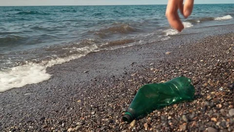 Closeup of volunteer picking up plastic bottle on the white ocean beach Stock Footage 110729264