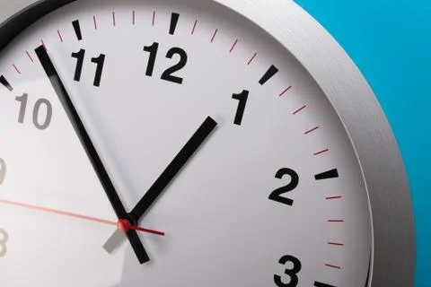 Closeup wall clock set on blue background. The concept of " The time is going Foto stock