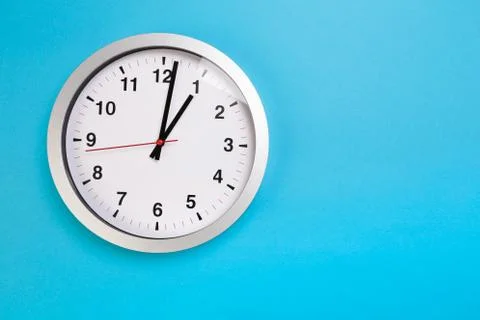 Closeup wall clock set on blue background. The concept of " The time is going Foto stock