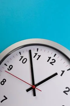 Closeup wall clock set on blue background. The concept of " The time is going Foto stock