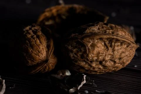 Closeup of walnuts with a dark mood on a rustic wooden background. Stock Photos