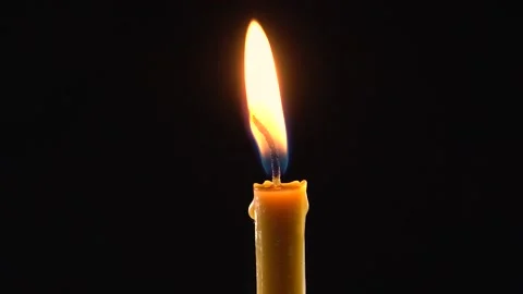 Closeup of a warm flame of a yellow wax candle. Black background. Stock-Footage 147570598