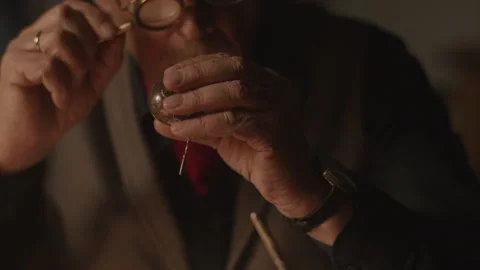 Closeup of Watchmaker checking an item using the magnifying glass Vídeo Stock 258301413