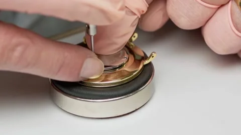Closeup of watchmaker´s hands using a screwdriver to assemble a golden Stock Footage 167573462
