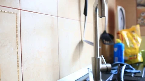Closeup of water dripping from a kitchen tap - water wasting concept Stock Footage 75939714