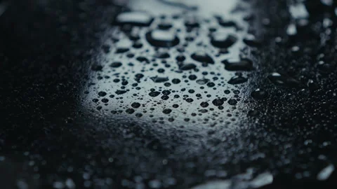 A CloseUp of Water Droplets on a Dark Surface, Capturing Natures Beautiful Stock Footage 309472325