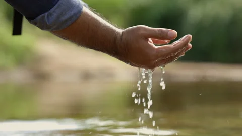 Closeup water drops falling down from man hand at river in mountains.Hand touchi Stock Footage 158789368