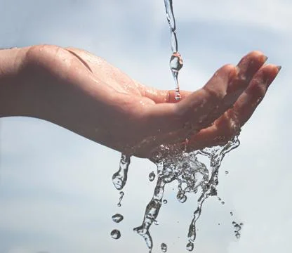 Closeup of water drops falling down through a human with a blurred blue light ba Stock Photos