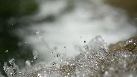 Closeup of water drops from a waterfall in the mountains (slow motion, bokeh) Stock Footage 219635878