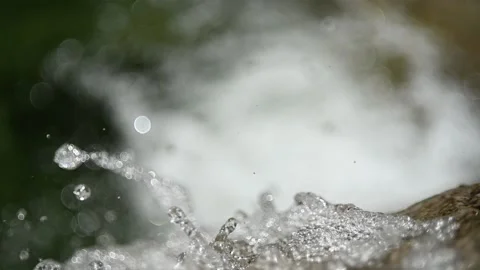 Closeup of water drops from a waterfall in the mountains (slow motion, bokeh) Stock-Footage 219635890