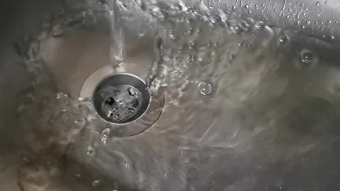 Closeup of water flows texture into the sink. Whirlpool in sink. Stock Footage 321292461