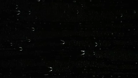 Closeup water rainfall, rain drops falling on window glass over black background Video stock 173587749