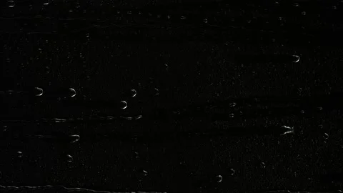 Closeup water rainfall, rain drops falling on window glass over black background Stock Footage 187425943