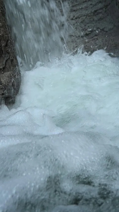 Closeup of a waterfall flushing into a pond, vertical shot, slow motion Stock-Footage 288325447