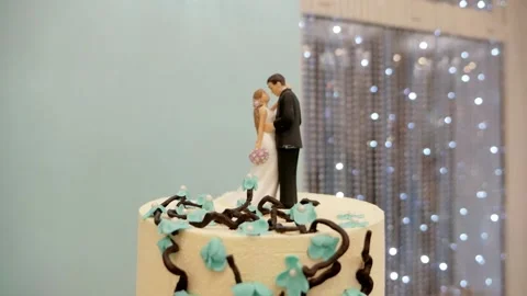 Closeup wedding cake in white and turquoise with figurines newlyweds Stock Footage 237112897