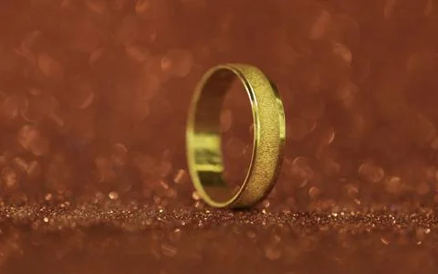 A closeup wedding ring on a red background Stock Photos