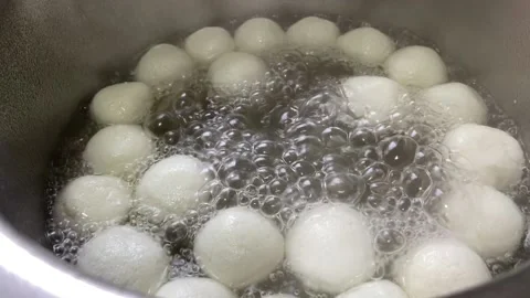 Closeup of white balls ( rasgulla) being boiled Stock-Footage 143666628