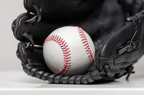 Closeup of a white baseball ball inside baseball glove Stock Photos
