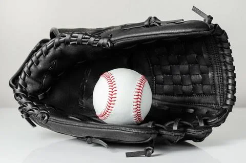 Closeup of a white baseball ball inside baseball glove Stock Photos