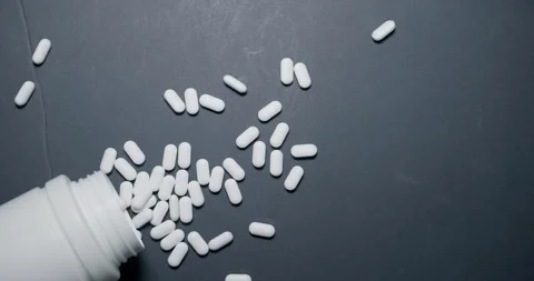 Closeup of White Bottle positioned on Dark Surface background Stock Footage 302880352