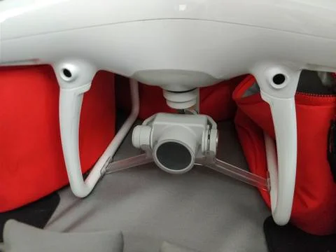 Closeup on white drone with camera at bottom of it. Stock Photos