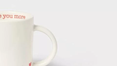 Closeup of white earthenware mug for Valentine's Day on copy-space background Fotos de archivo