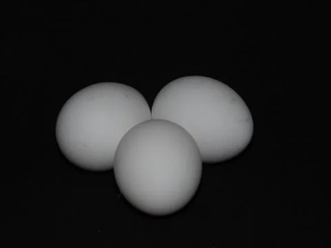 Closeup of white eggs isolated on black background Stock Photos