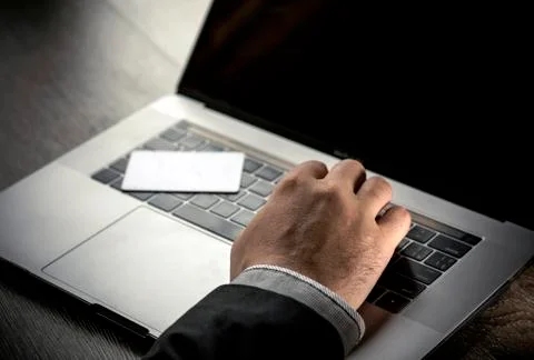 Closeup white electronic swipe card lying computer keyboard  and hand typing Stock Photos